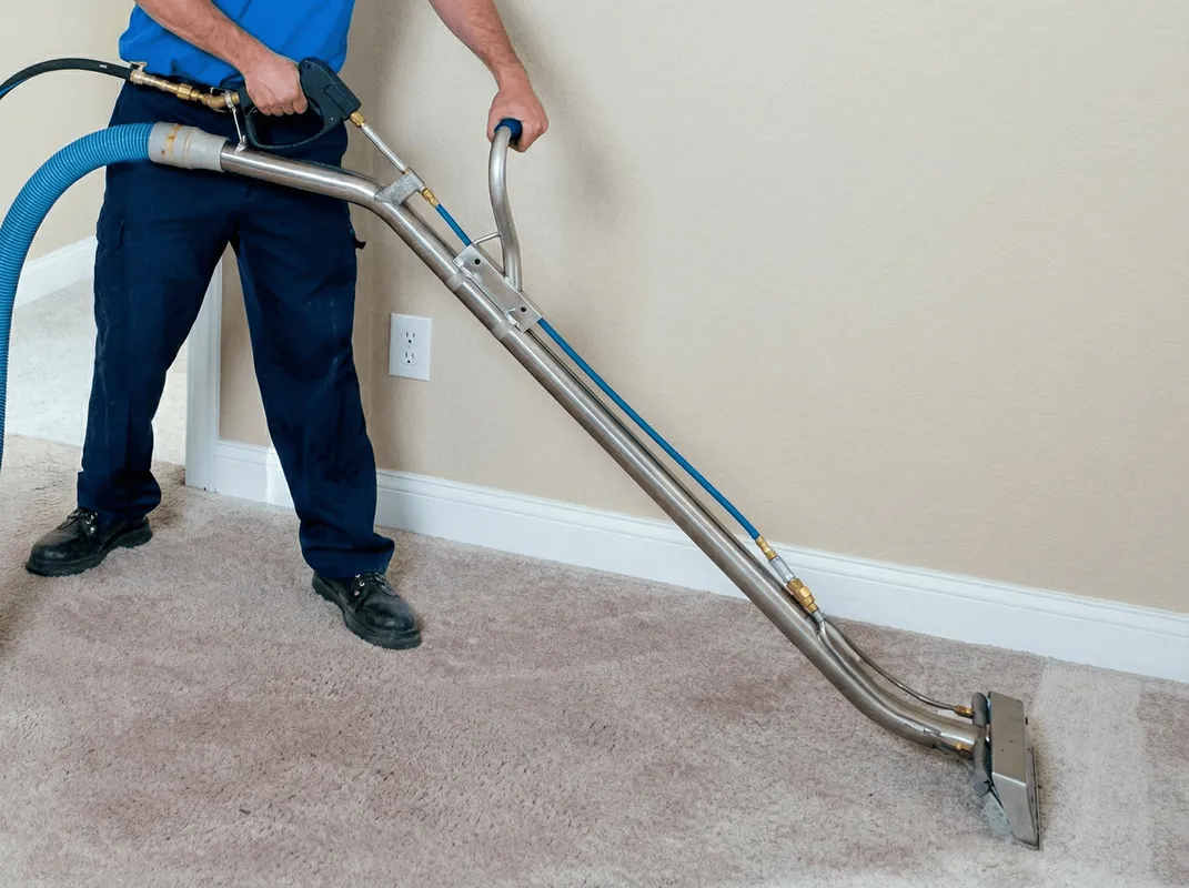 Professional operating a liquid removal machine on a carpeted floor in Kansas City, KS